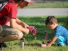 A volunteer, Kevin Berkley, teaching a boy, Leonardo Chavez, how to set up flags on the student union lawn, Sept.11, 2014. Photo: Yoshikazu Yamashita | The Telescope