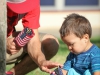 A volunteer, Kevin Berkley, teaching a boy, Leonardo Chavez, how to set up flags on the lawn, Sept.11, 2014. Photo: Yoshikazu Yamashita | The Telescope