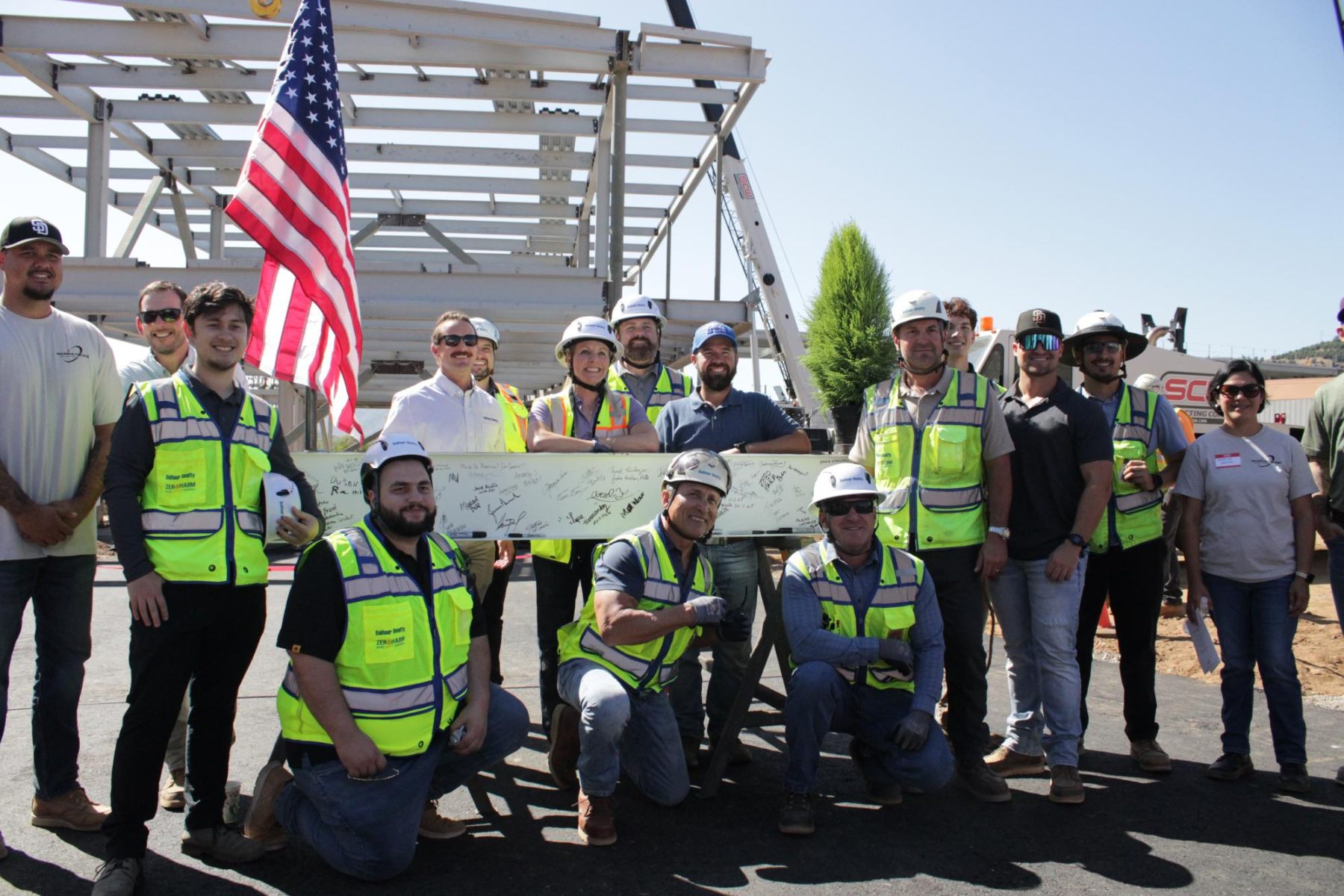 The construction crew poses with the beam before attaching it to be moved to the top of the structure at the beam signing ceremony at Palomar's Fallbrook campus on October 1.