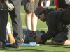 Palomar athletic trainer Dennis Greenhill stabilizes the neck of tight end Robert Ursua (80). Ursua was carted off the field on a stretcher and taken to the hospital by ambulance. Philip Farry / The Telescope.