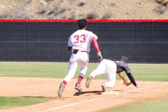 Baseball player wearing number 33 runs toward first base as the opposing first baseman stretches to catch the ball and make the out.