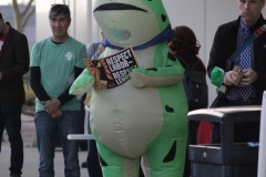 Matt Estes is in a frog inflatable suit holding a sign that says "respect labor, respect learning" and is standing outside the library.
