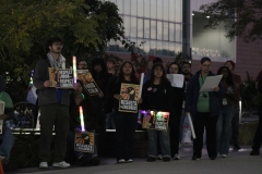 Students hold up signs that say "respect labor, respect learning" and they are holding glow sticks.
