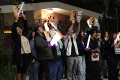 Students, staff, and faculty hold signs and chant as they look up at the room where the Governing Board meeting is taking place on Dec 16, 2025, at Palomar College. 