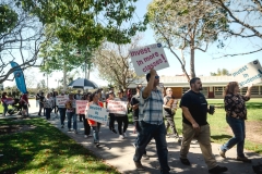 March in March attendees walking around in a group with their signs on the San Marcos campus on March 12.
