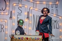 Beelzebub (Joshua DePaul, izquierda) y Astucia (Chavita Notez, derecha) atienden un kiosco estilo centro comercial, decorado con calaveritas de azúcar y series de luces, en “Pastorela Fronteriza” de Palomar. (Foto cortesía de Mariah Lambert)