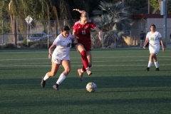 Dana Moore (#11) jumps after getting the ball past Jazelle Magallanes from the East LA Huskies. 