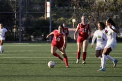 Eva Lopez (#19) dribbles the ball after receiving a pass from teammate Lizzy Cook (#21). Huskies Fatima Vasquez (#16) and Trish Calancha (#10) run towards Lopez to steal the ball from her. Photo credit: Griselda Garcia