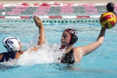 McKynley McCulloch (#14) is preparing to throw the ball to a nearby player. In contrast, Monserrat Rodriguez (#9) from Cerritos College attempts to block McCulloch's pass at the Women's Mini Water Polo Tournament on Sept. 5 at Palomar College. McCulloch scored five of the goals in the first game, with three back-to-back goals in the first quarter. Photo credit: Griselda Garcia