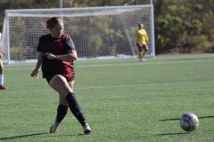 Keela Farnum (#13) in black is kicking the ball to a nearby teammate who is not shown.Keela Farnum (#13) passes the ball to a nearby teammate during the first half of the game on Oct. 3 at Minkoff Field at Palomar College. 