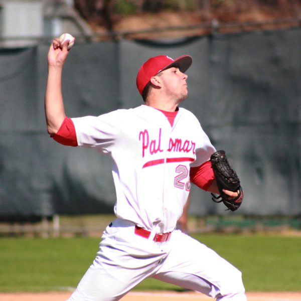 A male Palomar baseball player cocks his right arm back to throw a baseball.
