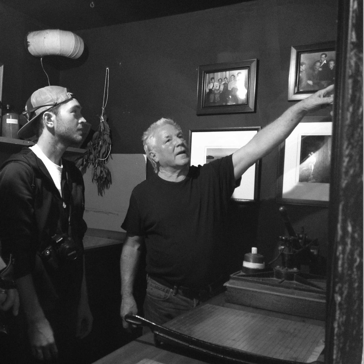 Professional photographer Kim Weston shows students Daniel Kresge and Dirk Callum his images at his home in Carmel, Calif. (Photo courtesy of Donna Consentino)