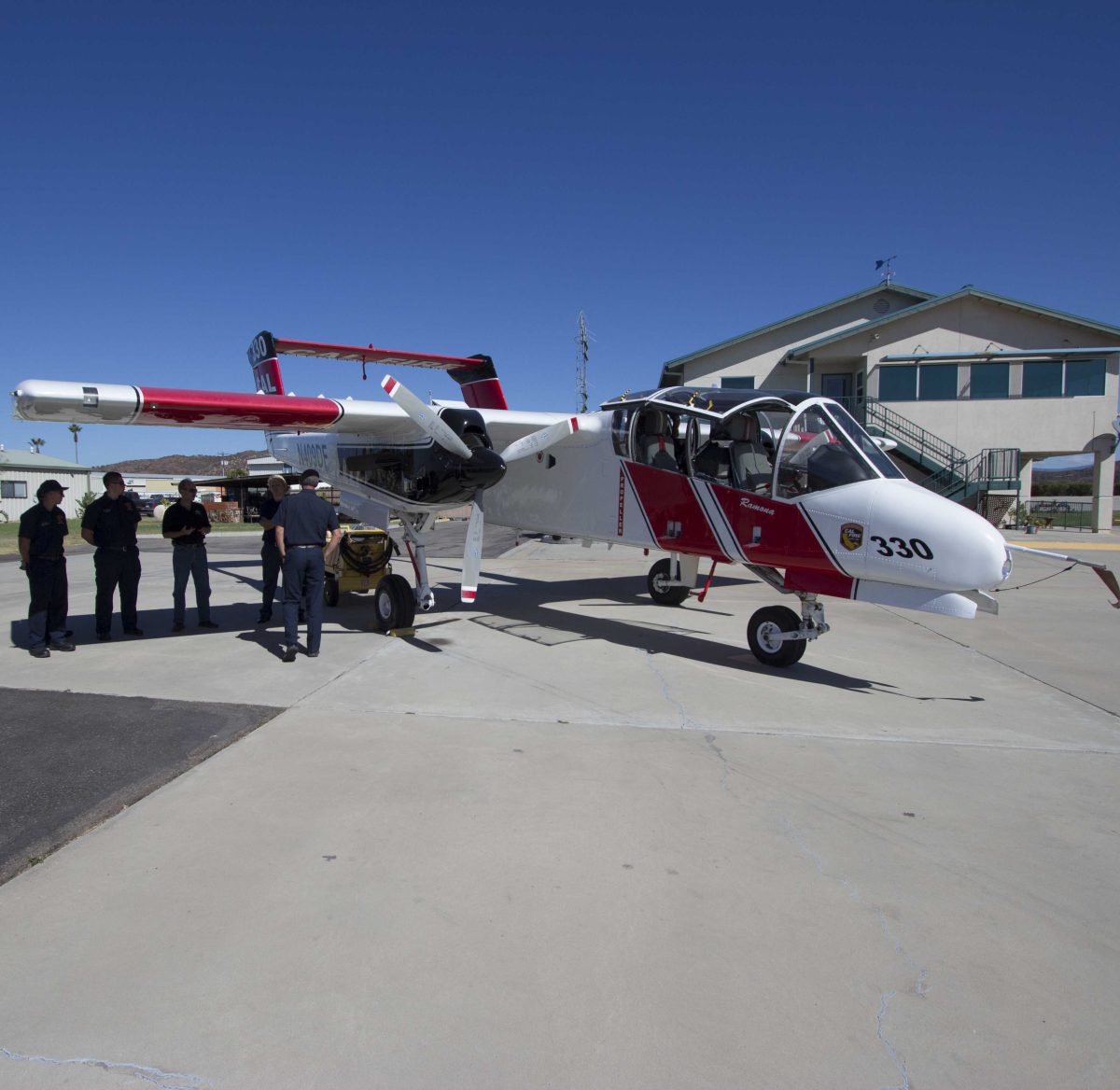 Palomar College Fire Club tour the Ramona Cal Fire Air Field. Fire Club members stand under the wing of the Cal Fire spotter plane as Captain Todd O'Carroll explains the planes purpose. Sept. 26, 2014. (Paul Nelson/The Telescope)