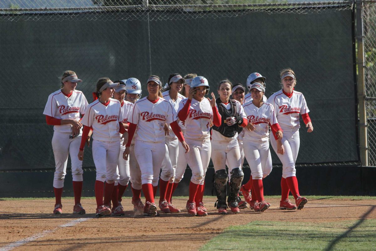 The Palomar Women's Softball team wait at home base for teammate Brooke Huddleson (4) to congratulate her on the home run hit that resulted in 3 points for Palomar against Mt. San Antonio, April 4, 2015 Palomar had previously beaten Santiago Canyon College during their first double-header game 5-2, and came out on top of Mt. San Antonio 4-1. (Dirk Callum/The Telescope)