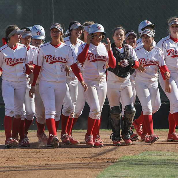 The Palomar Women's Softball team wait at home base for teammate Brooke Huddleson (4) to congratulate her on the home run hit that resulted in 3 points for Palomar against Mt. San Antonio, April 4, 2015 Palomar had previously beaten Santiago Canyon College during their first double-header game 5-2, and came out on top of Mt. San Antonio 4-1. (Dirk Callum/The Telescope)