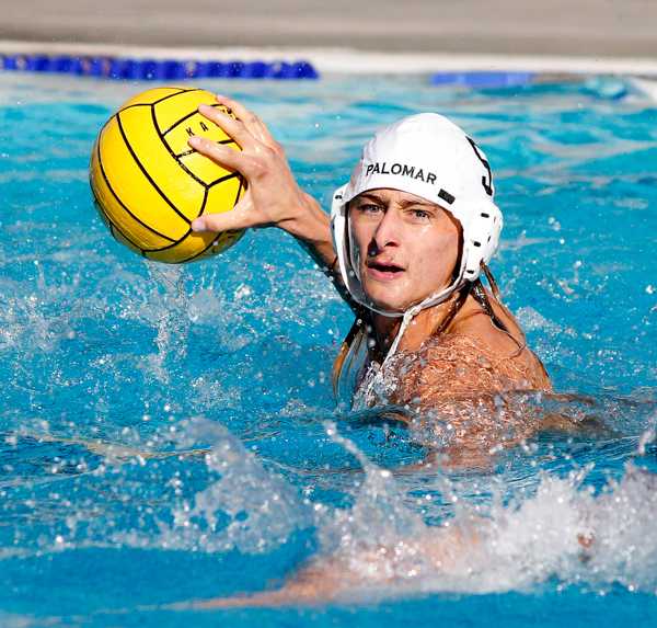 A male Palomar water polo player throws a ball with his right hand.