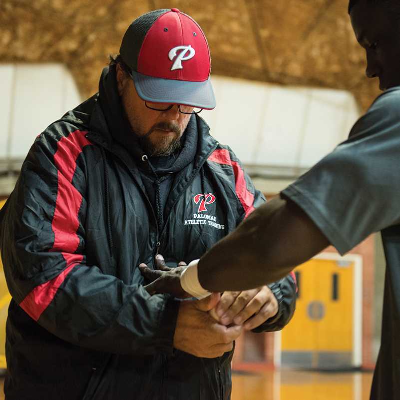 Palomar trainer, Dennis Greenhill, wraps up wrestler, Seville Hayres prior to the evenings competition against Santa Anna College at the Dome, Palomar College, Wednesday, Oct. 28, 2015. (Brandy Sebastian/The Telescope)