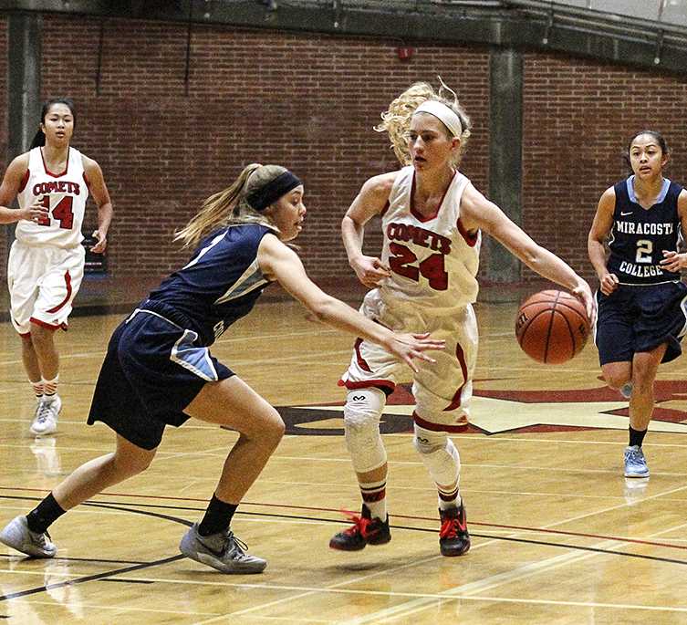 Palomar's Cheyenne Ertz (24) dribbles the ball up court during the women's basketball game against Mira Costa at the Dome on Jan. 27. Mira Costa's Danielle Bosley (1) tries to deflect the ball while teammate Kim Noland (2) trails along with Palomar's Roshell Lamung (14). The Comets won 83-34. (Coleen Burnham/The Telescope)