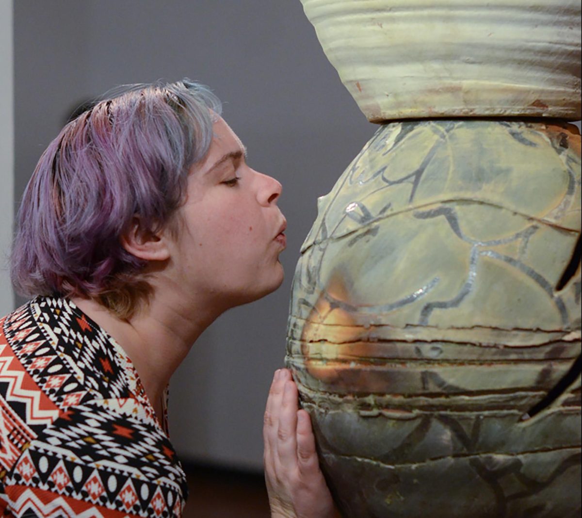 Gallery attendee Michelle Hauswirth blows into ceramic artist Jessica Rae Thompson's sculpture thereby creating a whistle sound during the Ceramics Biennial at the Palomar College Boehm Gallery on Feb. 18, 2016. (Tracy Grassel/The Telescope)