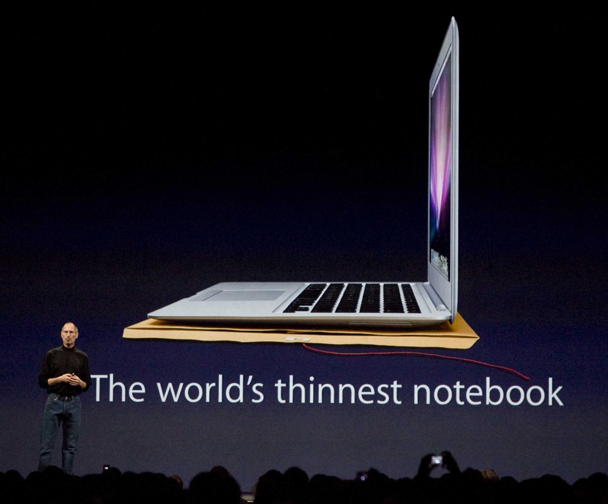 Apple CEO Steve Jobs stands in front of a screen with a picture of an Apple Macbook laptop with the text "The world's thinnest notebook" below it.