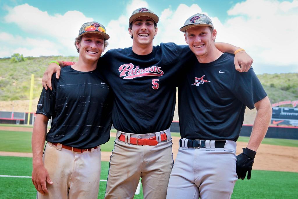 Three Palomar baseball players smile for a picture with their arms around each others' shoulders. They're wearing black T-shirts and white pants.