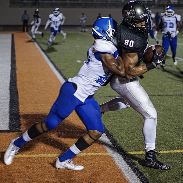 A Corsair football player tackles a Palomar player who is holding a football in his right hand near the touchdown line.