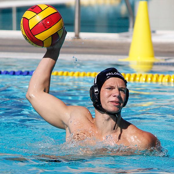 A male Palomar water polo player throws a ball with his right hand.