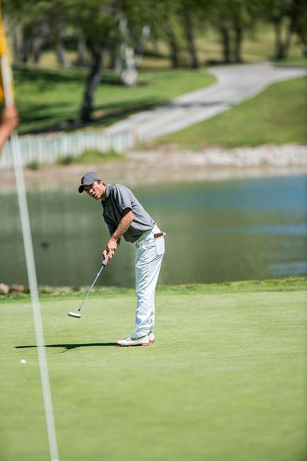 Palomar's Pat Gorman putts a golf ball. A small flag is in the foreground leaning toward the left (blurry).