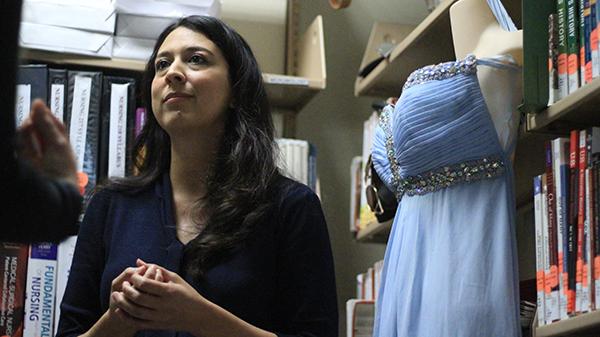 Librarian Natalie Lopez with one of the donated dresses for The Princess Project. (Coulter Mohill Smith/The Telescope)