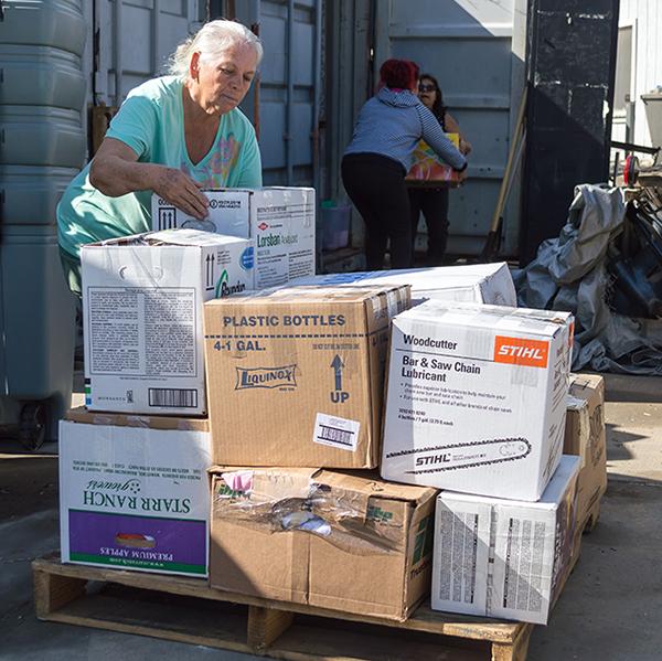 Palomar ESL students, Cristina Valadez places a box on a pallet while Azucena Hernández, takes a box from Virginia Méndez, preparing to ship to Rockport, Texas, for hurricane relief. Nov. 3, 2017. (Raffaele Reade/The Telescope)