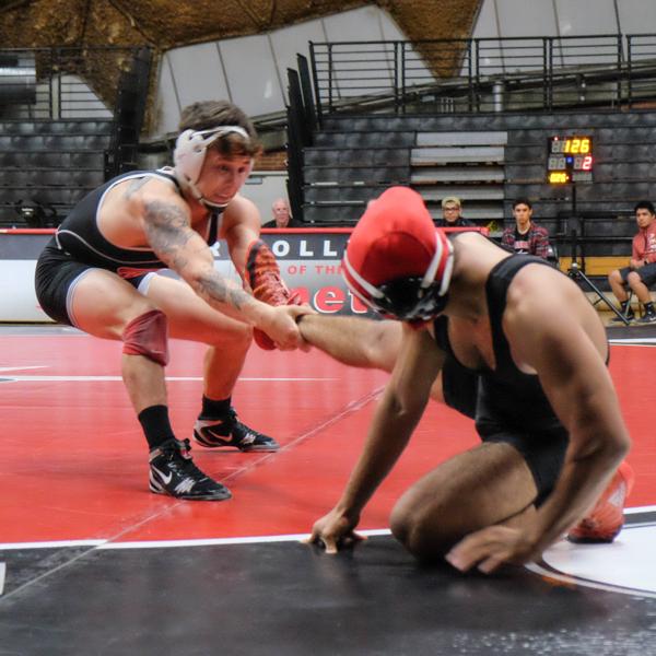 A male Palomar wrestler (l) pulls his opponent's right leg as he tries to drag him.