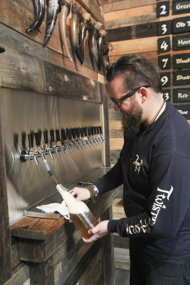 Worker, Aric Radcliffe, pours a bottle from tap at the Twisted Horn, Apr 6. Taylor Hardey/The Telescope