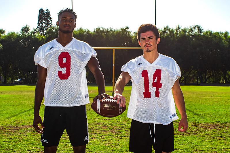 Palomar football players Kyran Griffin and Johnny Armentrout stand next to each other, holding a foot together with one hand. (Kevin Mijares/The Telescope)