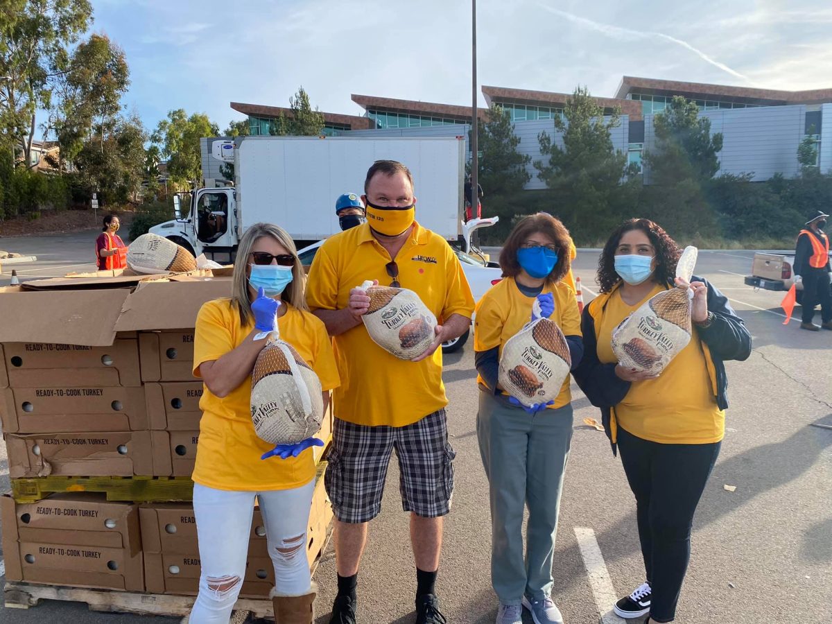 Palomar employees hand out frozen chicken at Palomar food drive in December 2020.