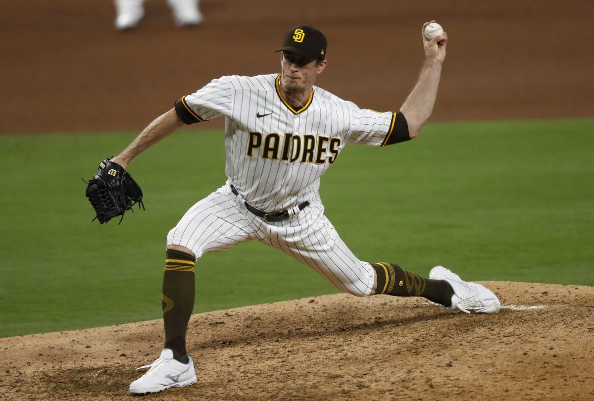 San Diego Padres pitcher Tim Hill winds up to throw a baseball from a base with his left hand.