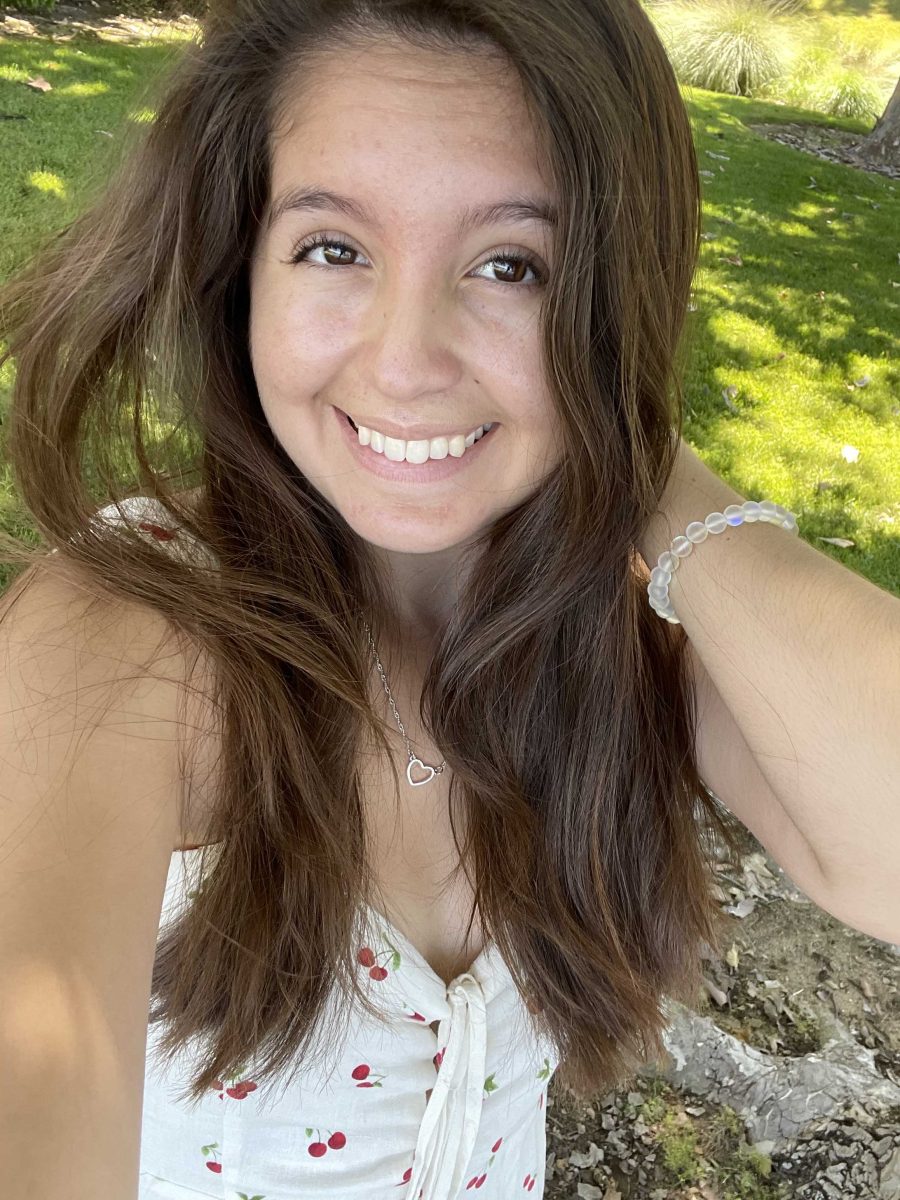 Palomar student Lucinda Salazar takes a selfie with her left hand behind her left shoulder and long brown hair.