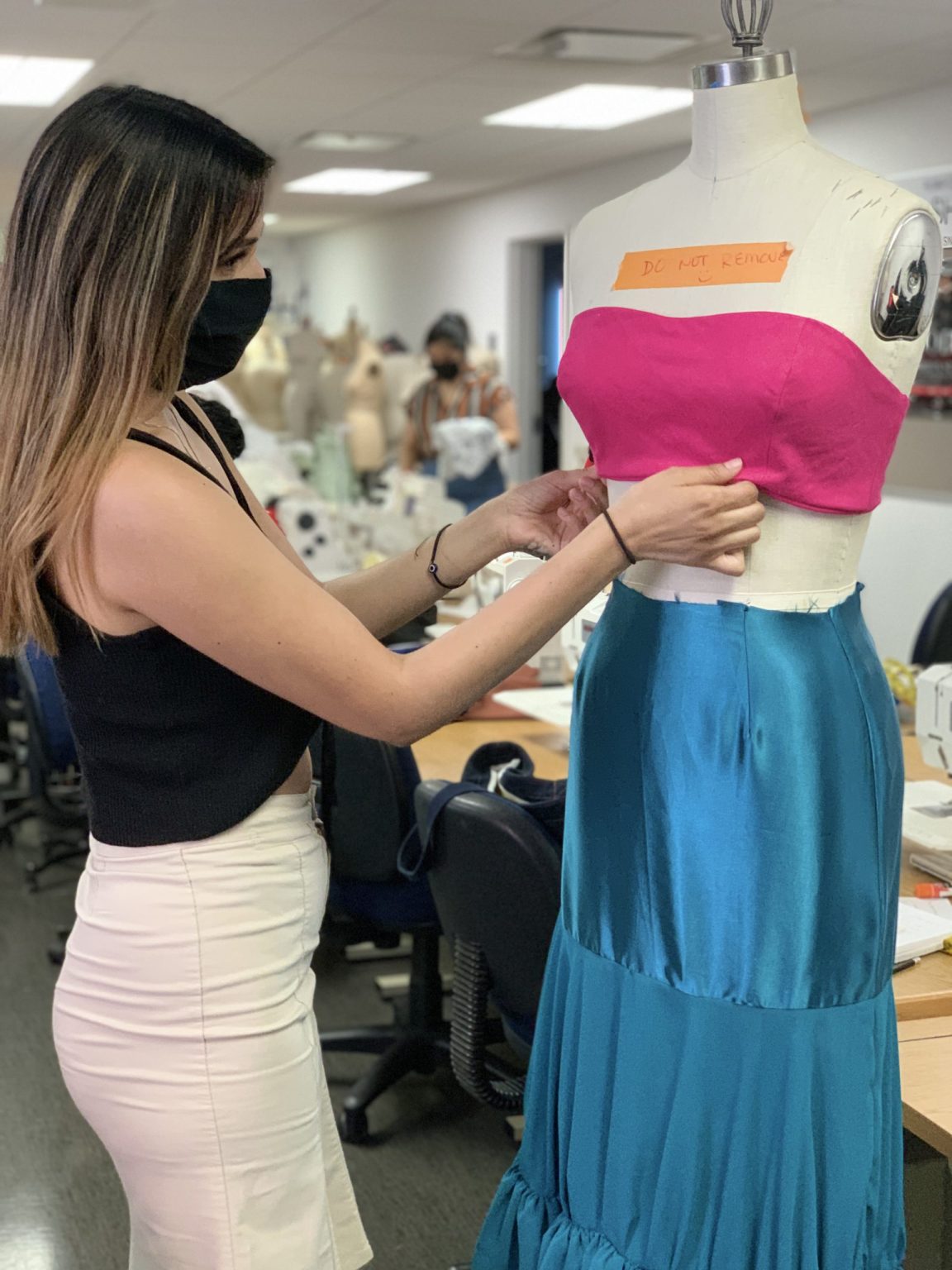 Alexis Solorio adjusts her design for the 2022 MODA Fashion Show. (Sophia Partida/IMPACT Magazine)