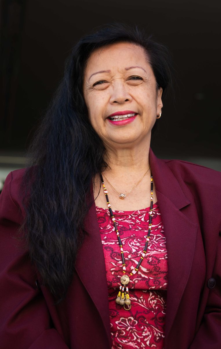 Portrait of a woman wearing a red suit smiling.