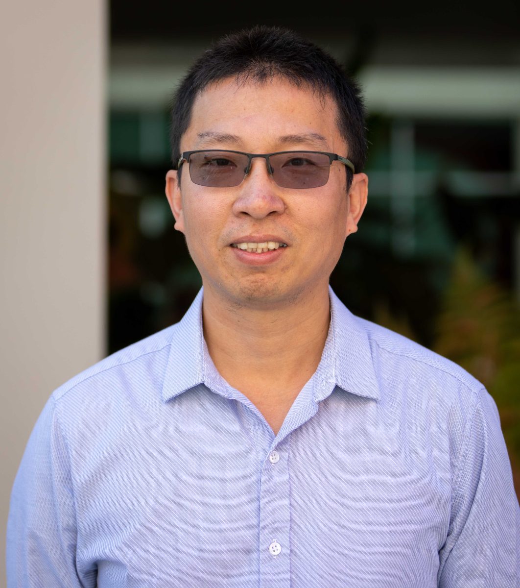 Photo of a man of Chinese descent wearing a gray-collar shirt.