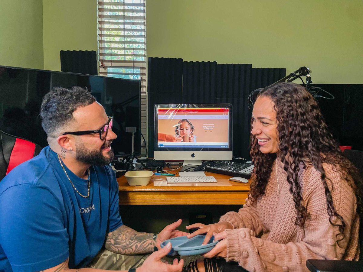 Dre'As and Brooke Sanchez discussing one of their company's products in their office at home.