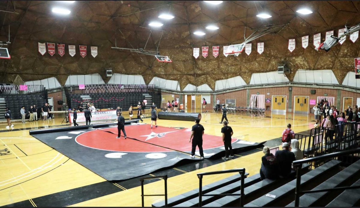 A group of people prepares the upcoming women's wrestling match at The Dome.