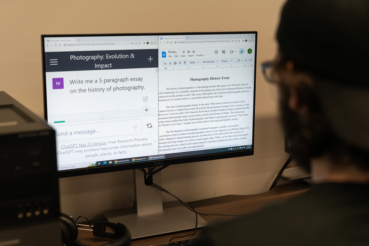 Man looks at computer screen with Open AI’ homepage of ChatGPT.