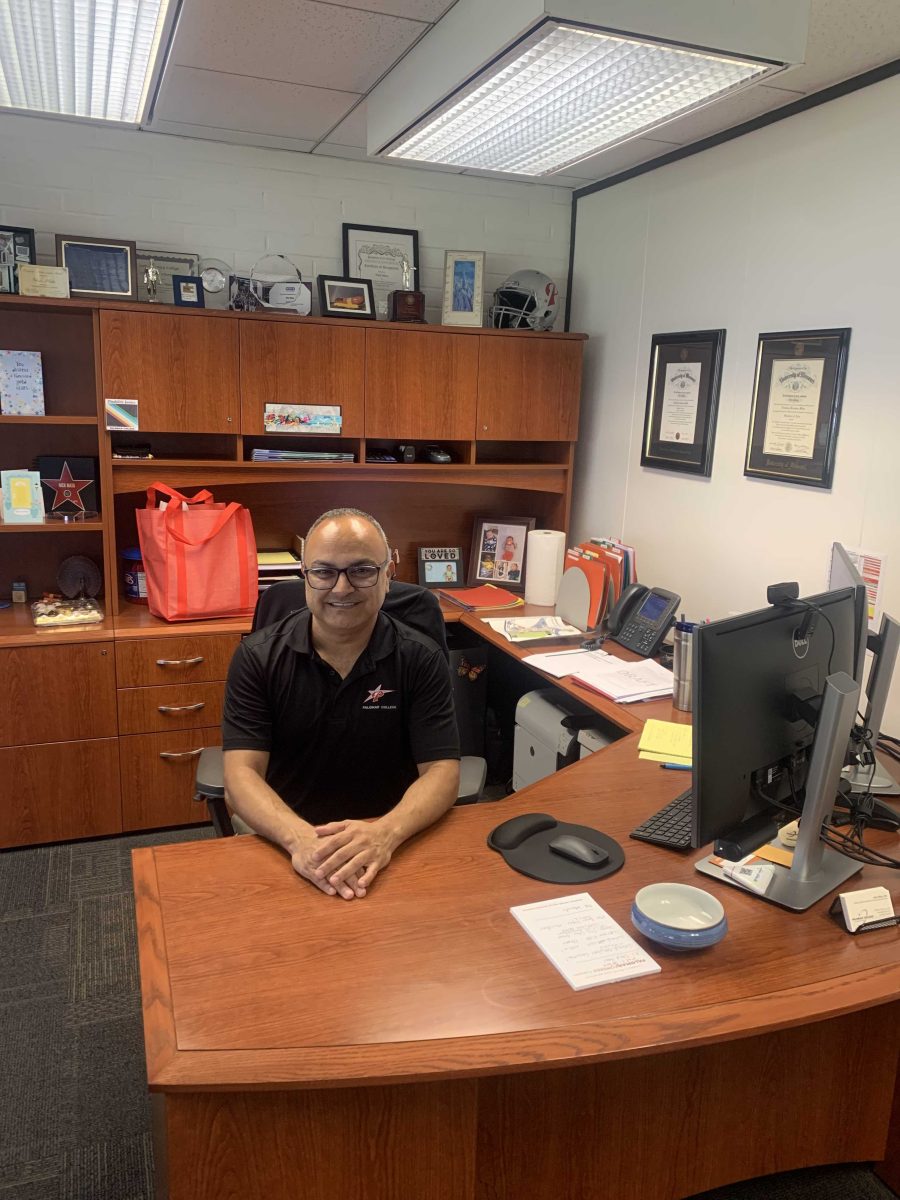 Vice President of Student Services, Nicolas Mata sits at his desk in his office. 