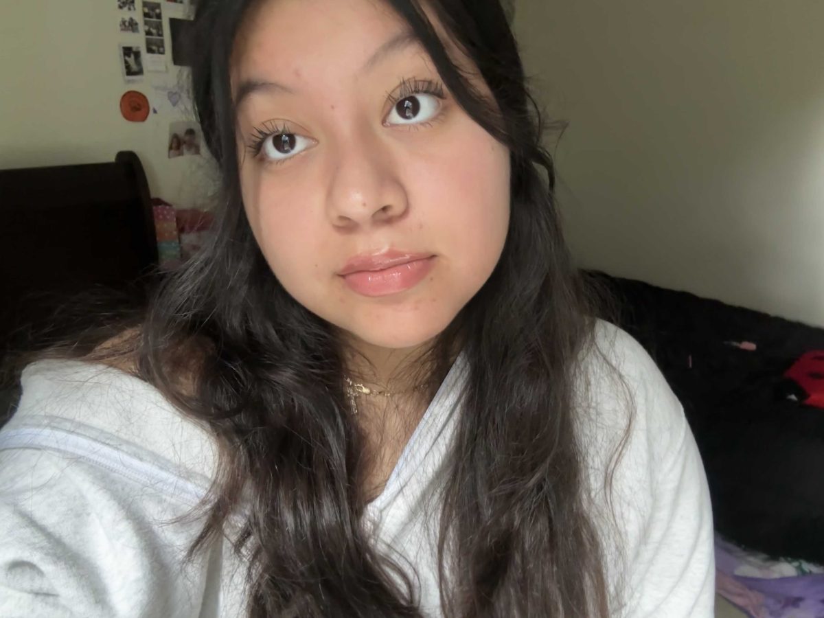 Photo of a brunette wearing a white shirt and looking past the camera.