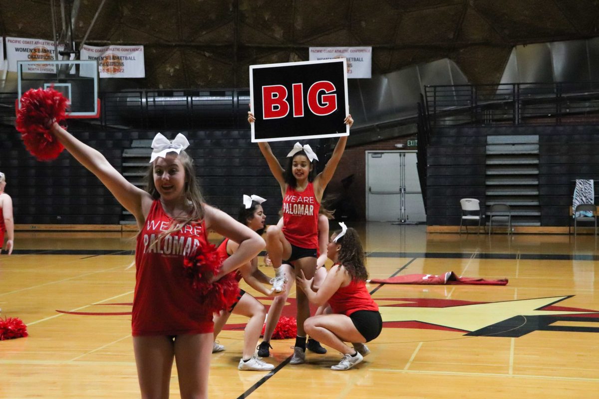 Alex Mateko (front) strikes a pose as bases Hailey Pickett (left) and Alyssa Ruiz (right) get ready to lift up flyer Mallory Fikas. Photo credit: Alex Ortega