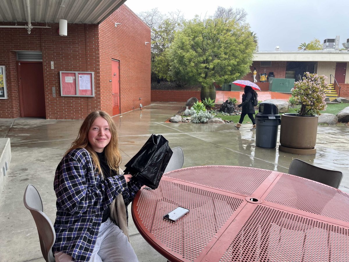 Palomar student, Maya Jaramillo, basks in the rain as she hangs out at one of the tables outside of the cafeteria. Photo credit: Josh Miranda