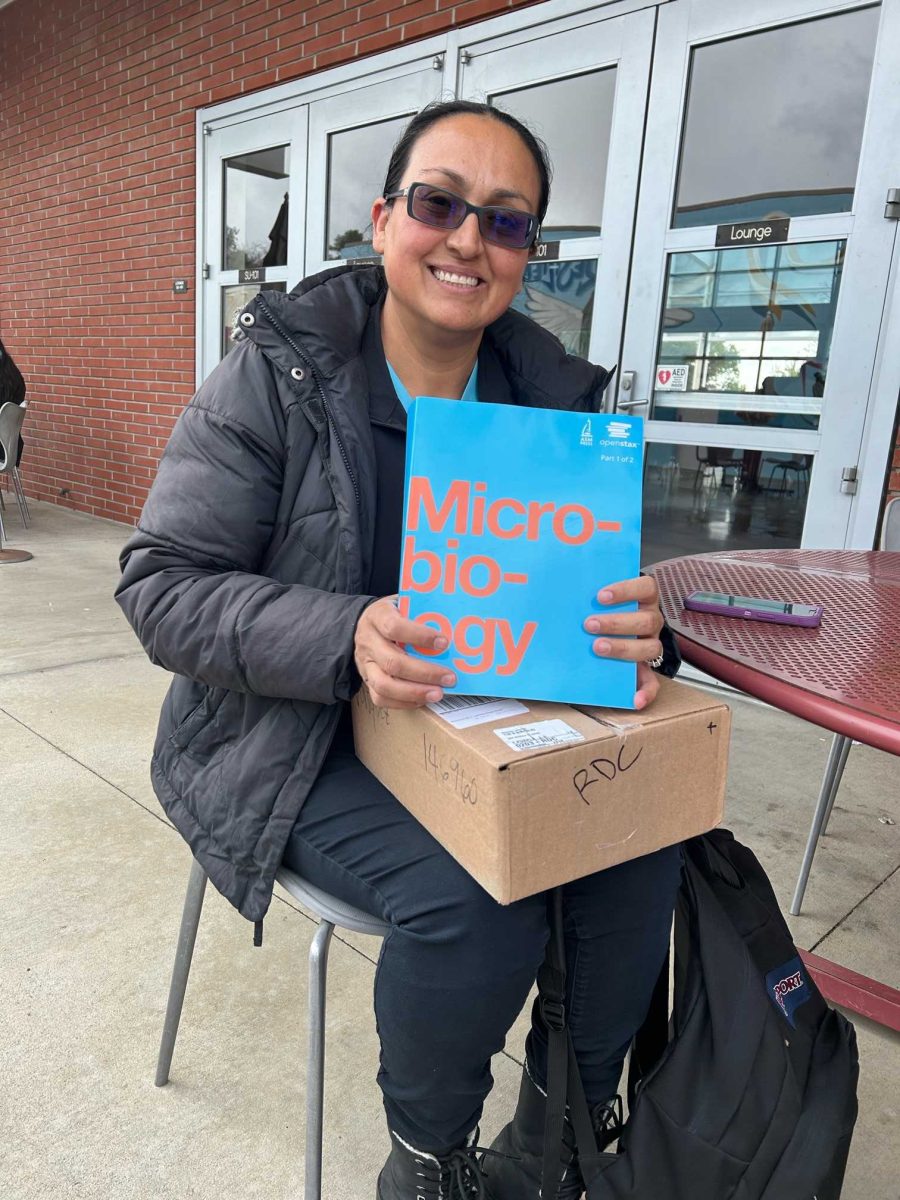 Rosario Vasquez poses with her Micro-biology textbook outside of the Student Union building. Photo credit: Ale Zbinden