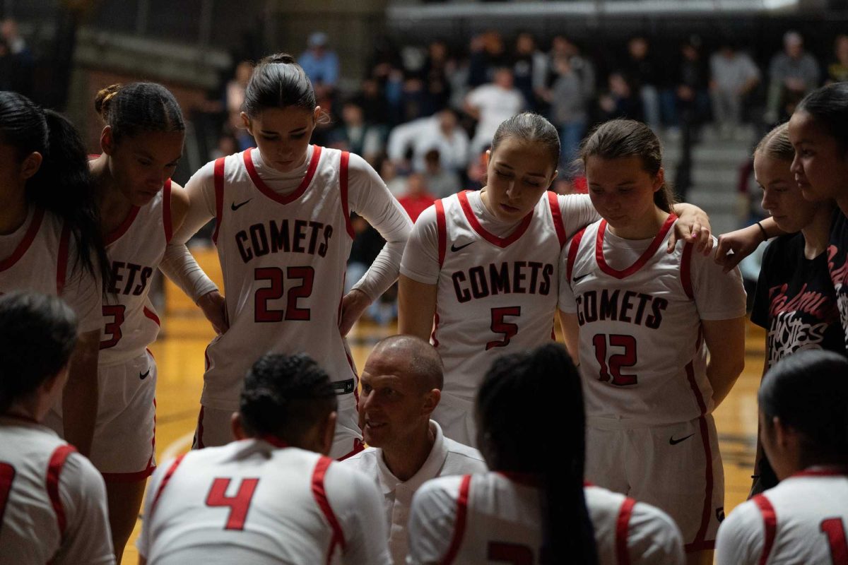 Palomar basketball team (Macyn Raleigh, Angelina De Leon, Faith Brinkman, Evelyn Terraza, Brooke Quintana) surround the coach (Chris Kroesch) during a timeout huddle. Photo credit: Hector Flores