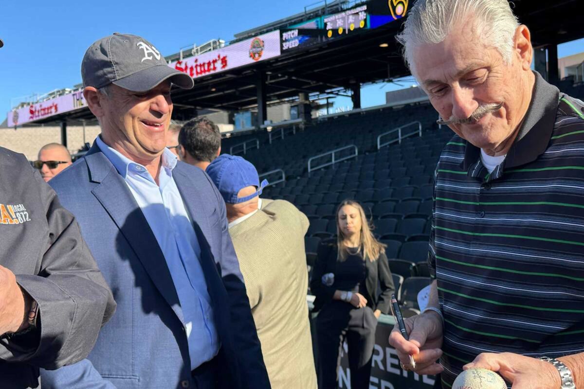 Oakland Athletics owner John Fisher (left) and A's hall of fame pitcher Rollie Fingers sign a baseball for a fan at Las Vegas Ballpark on Friday, March 8, 2024. (Mick Akers/Las Vegas Review-Journal/TNS) Photo credit: Mick Akers