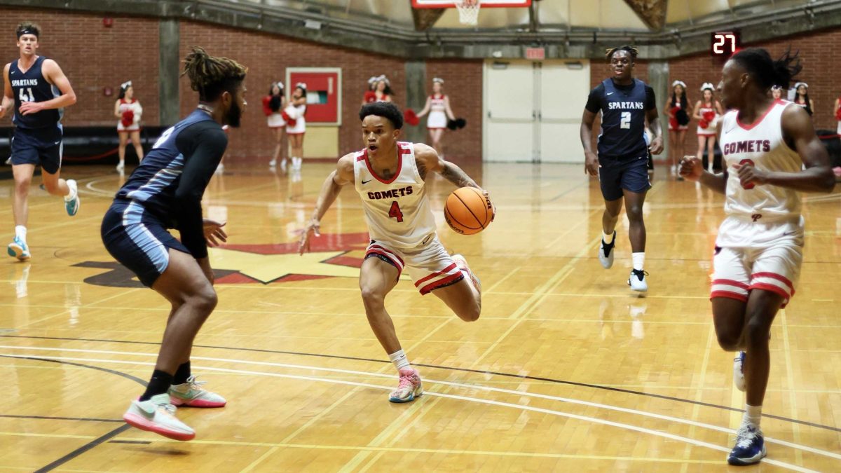 Comets guard Spivey Word dribbling the basketball.